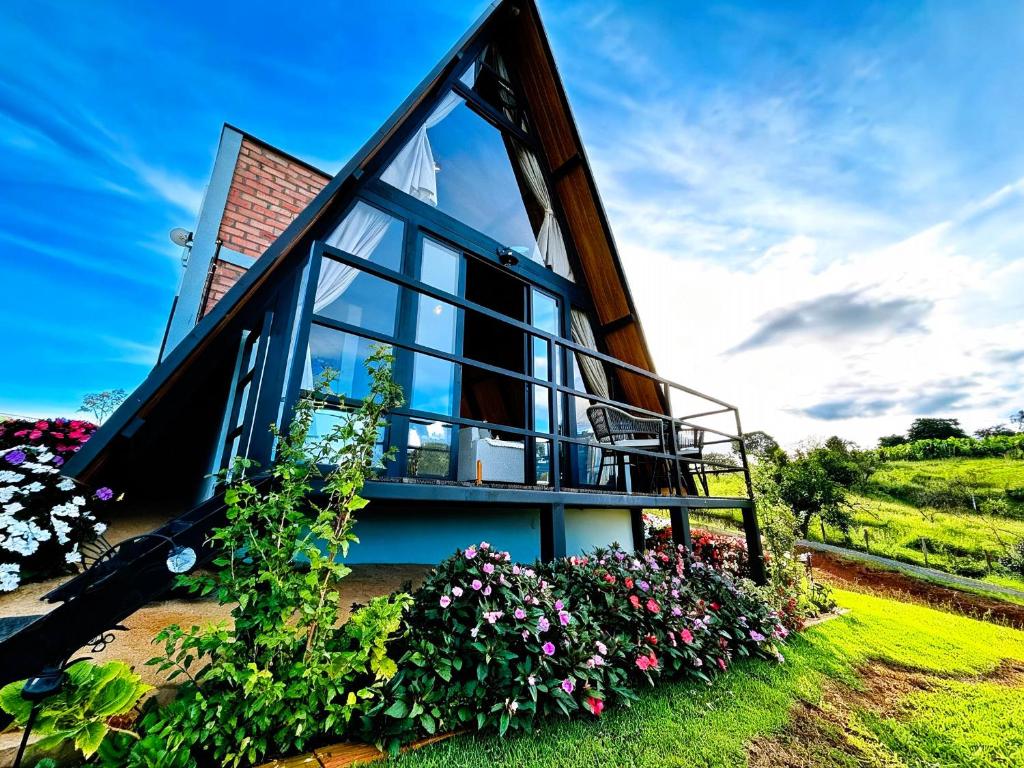 a house with a large window and some flowers at Refugio Pertinho do Céu in São Pedro