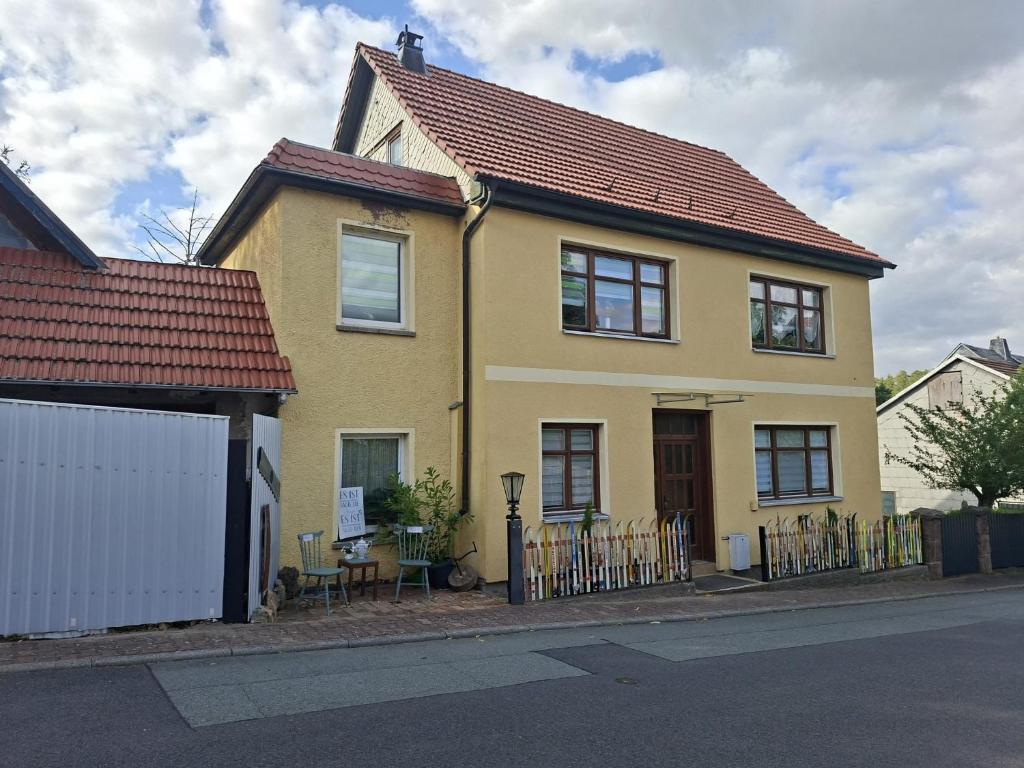 a yellow house on the side of a street at Horstis Fewo Apartment Reni in Frankenhain
