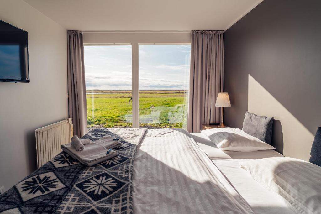 a bedroom with two beds and a large window at Farmhouse in Vík