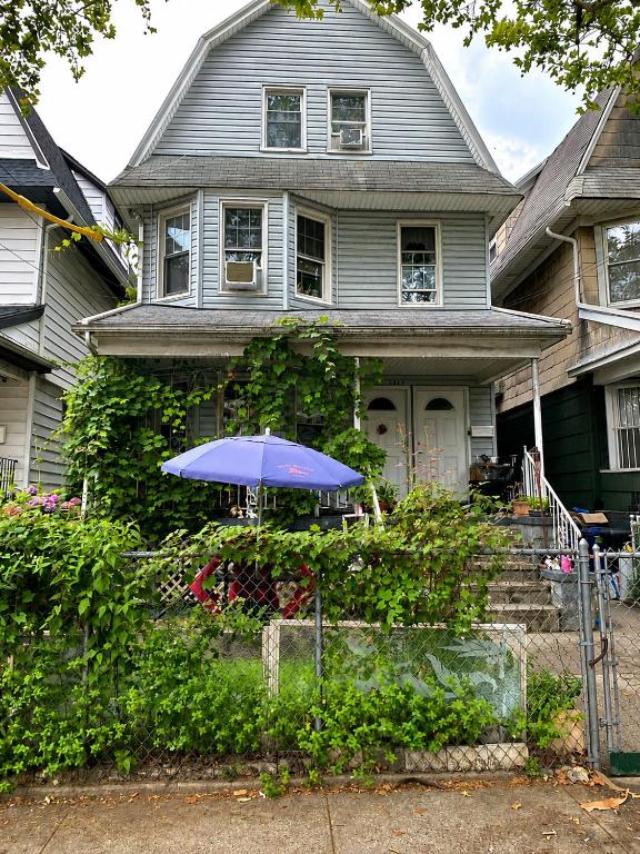 a house with a blue umbrella in front of it at Classical American House 4 in Brooklyn