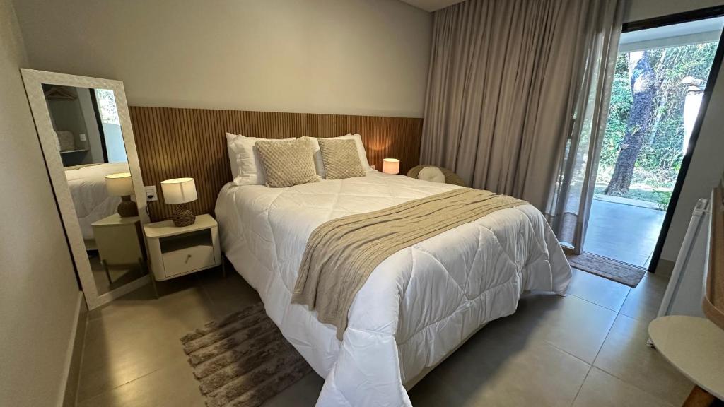 a bedroom with a large bed and a large window at Pousada raios de sol in Chapada dos Guimarães
