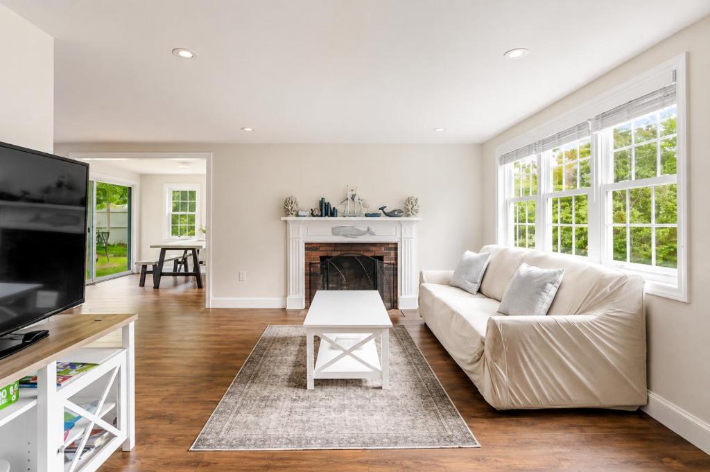 a living room with a couch and a fireplace at Dennis Beach House - Walk to Beach - Pet Friendly in Dennis
