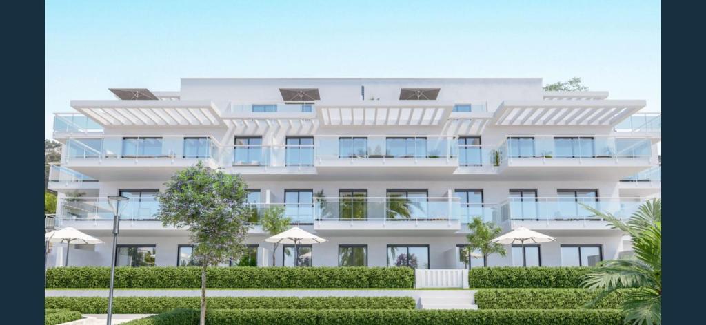 a large white building with umbrellas in front of it at Luxury La Cala de Mijas Sunset in Mijas Costa