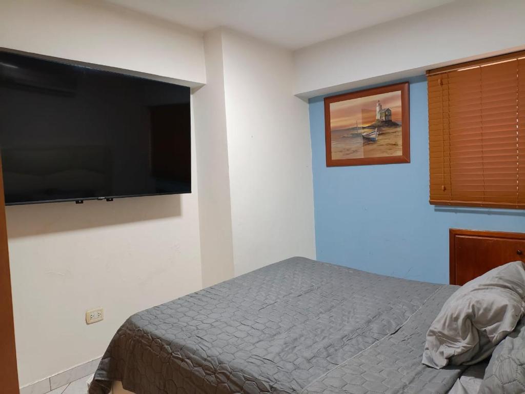 a bedroom with a bed and a flat screen tv at Apto RE 1 in El Morro de Barcelona
