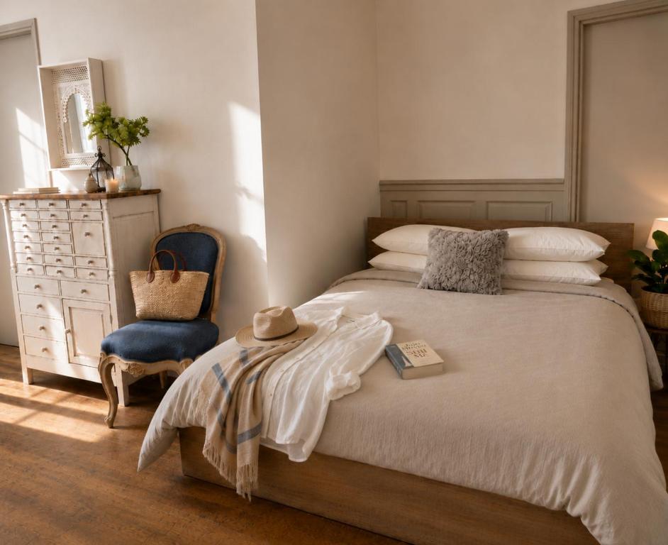 a bedroom with a bed and a blue chair at Fontaine Studio Appartement in Ribérac