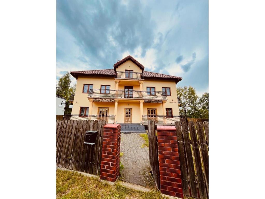 a large yellow house with a fence in front of it at Double room, sauna, Masuria in Ruciane-Nida