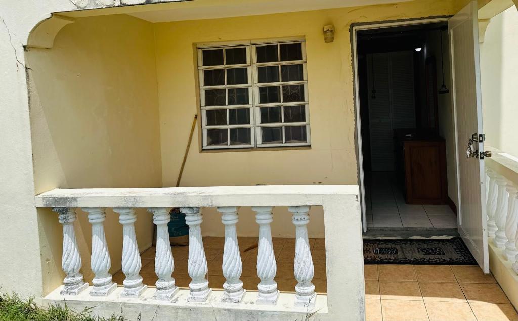 a porch with a white railing and a window at Guest house 2 in Upper Conaree