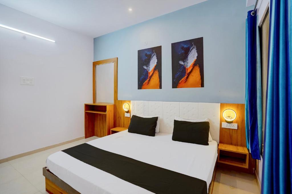 a bedroom with a white bed and two paintings on the wall at Hotel O City Star in Rewa