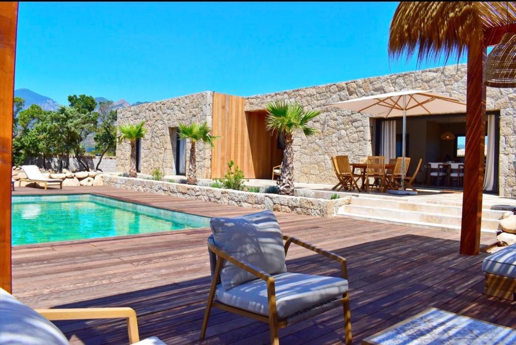 a villa with a swimming pool and a wooden deck at Villa Rosa, 4chambres, piscine , Lecci , 8 personnes in Lecci