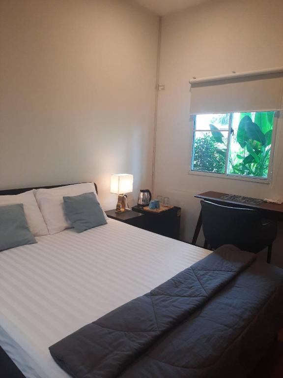 a bedroom with a large bed and a window at Hidden courtyard in Ban Bang Phun
