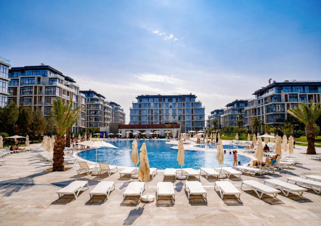 a swimming pool with lounge chairs and a resort at Cozy family apartment at Seabreeze Nardaran, Beach & Pool, Polo Residence in Baku