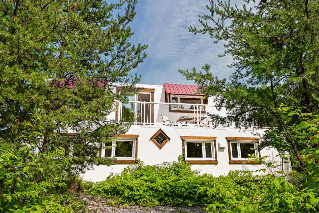 a white house with trees in front of it at Maison Conteneur d'Expedition in Amos