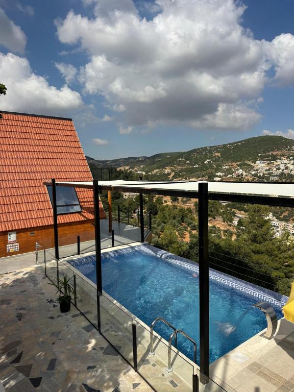 a swimming pool on the balcony of a house at أكواخ المها oryx cottage in Ajloun