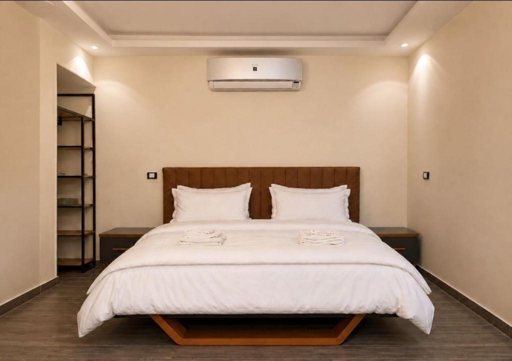 a bedroom with a large bed with a white comforter at Pyramids Gardens 2bedroom apartment in ‘Ezbet `Abd el-Ḥamîd