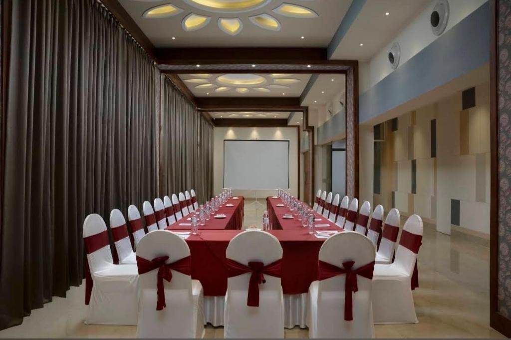 a conference room with a long table and white chairs at Resort Rio in Arpora