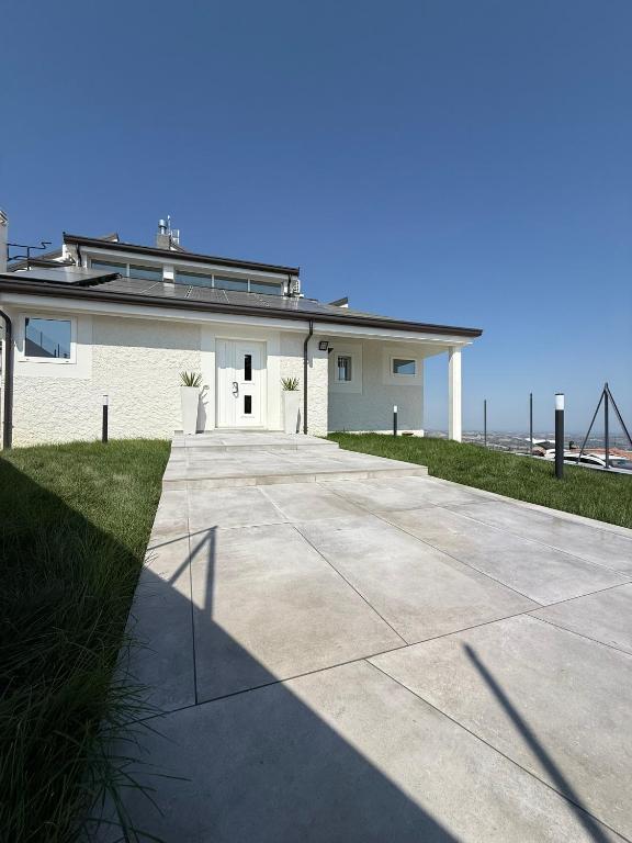 a large white building with a driveway next to the ocean at B&B Remì in Gemmano