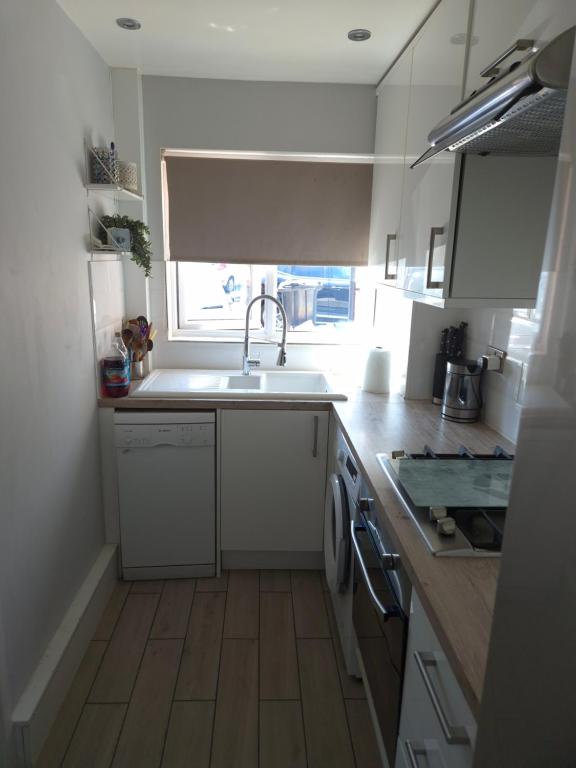 a kitchen with a sink and a dishwasher at 2BR home in Twickenham in Hounslow