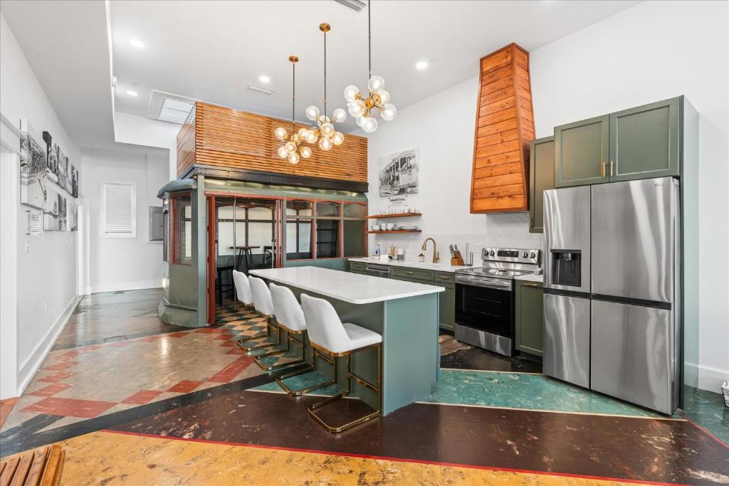 a kitchen with a table and a refrigerator at Downtown Mobile Pets Ok Walkable Secure Parking in Mobile