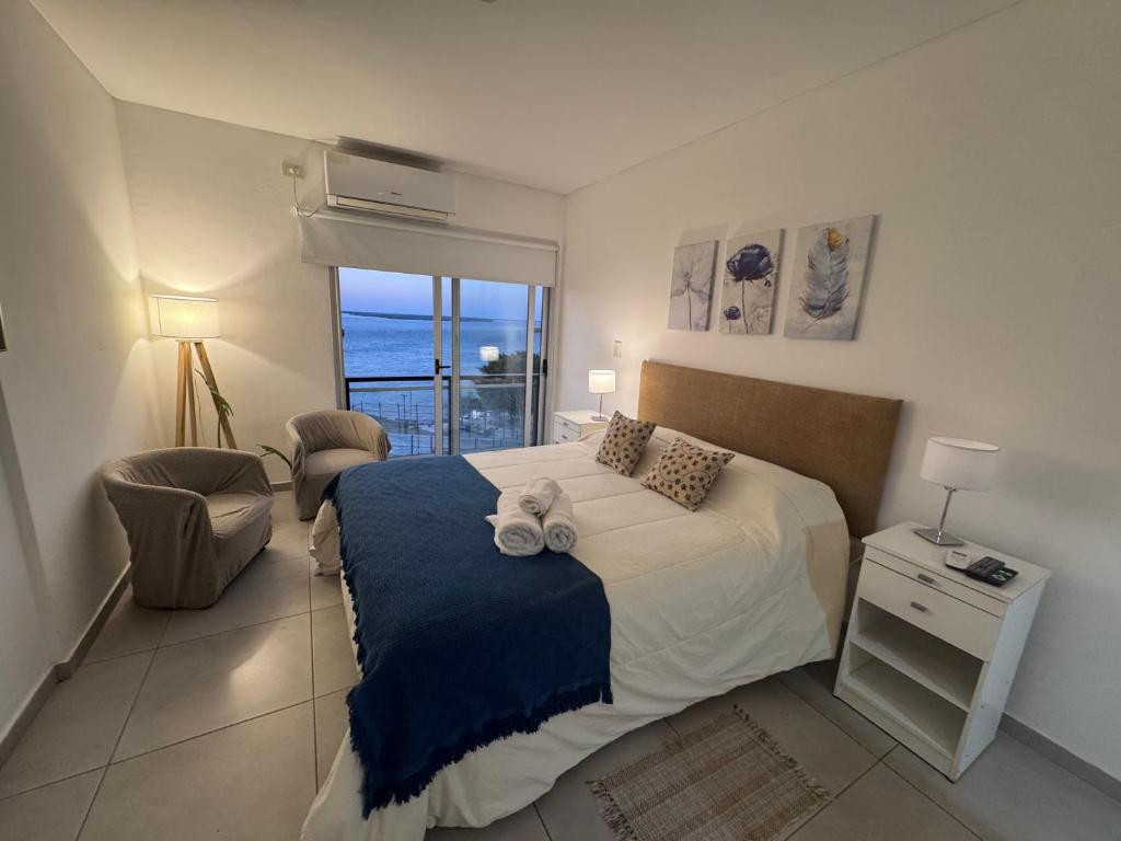 a bedroom with a bed and a balcony with the ocean at Departamento sobre el Rio. in Corrientes