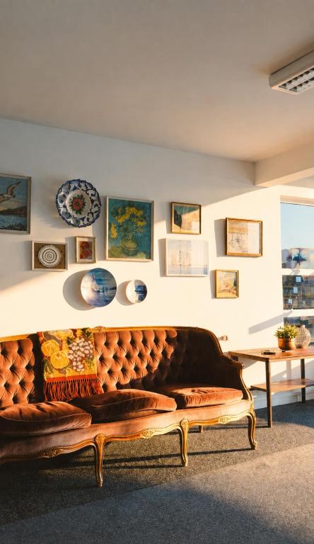 a couch in a room with a table and plates at Eldey Airport Hotel in Keflavík
