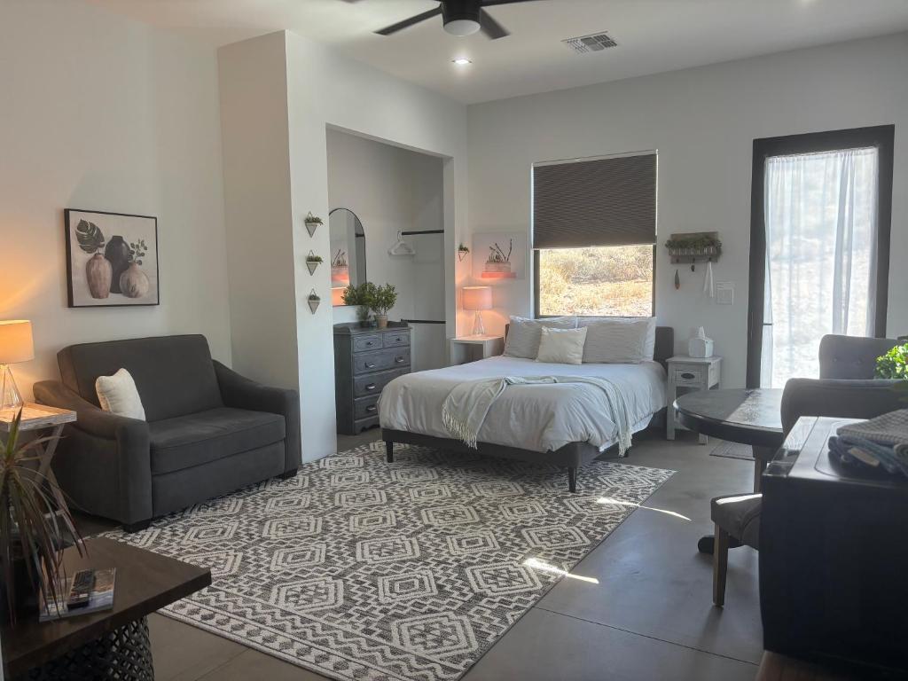 a bedroom with a bed and a couch and a chair at Lazy G Ranch Casita 