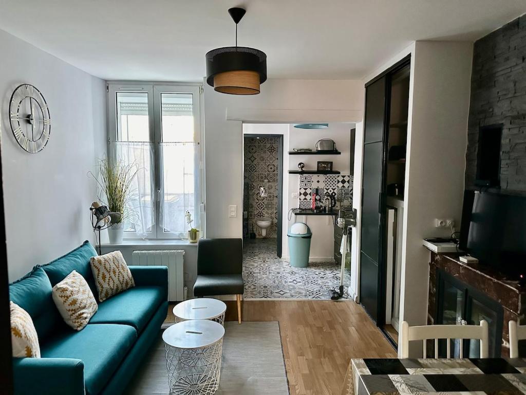 a living room with a blue couch and a fireplace at Cocon entre centre ville autoroute in Reims