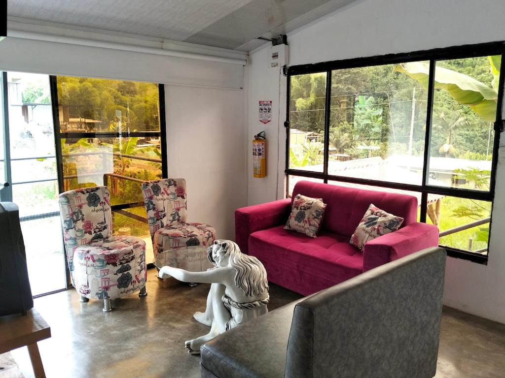 a living room with a pink couch and a dog statue at Las Margaritas Cabin in Chinchiná