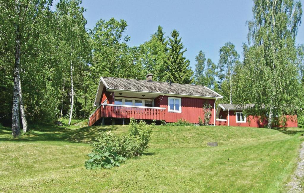 a red house on a green hill with trees at Awesome Home In Munkedal With Wifi in Munkedal