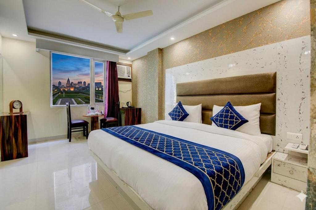 a bedroom with a large bed and a window at company Of Hotel in New Delhi