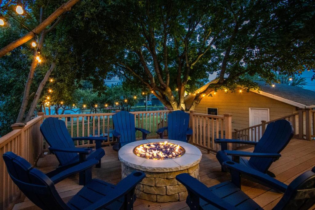 a fire pit on a deck with chairs and lights at CozyLiving in Billings