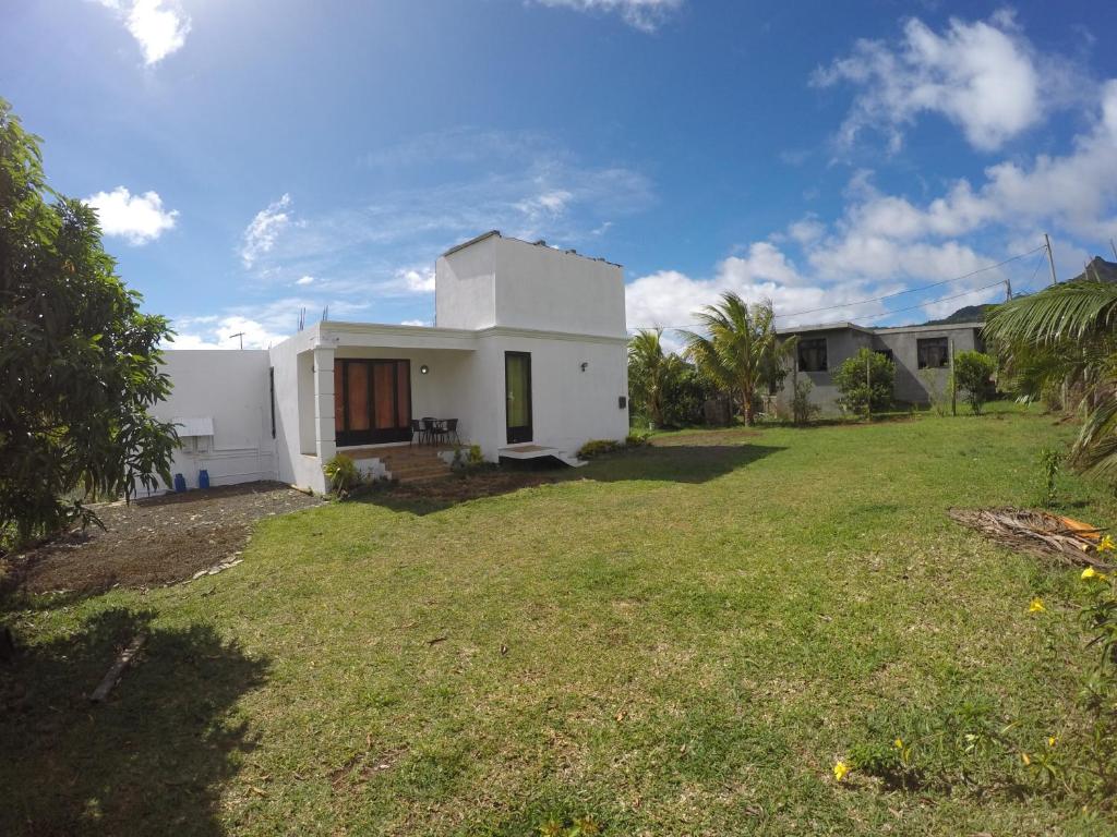 a white house with a yard in front of it at Chamarel Mirador Studio in Chamarel