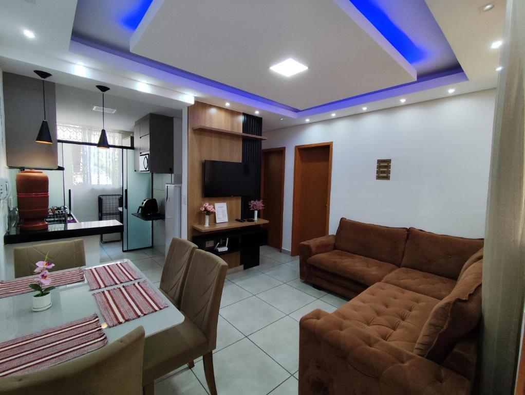 a living room with a couch and a table at Apartamento Moderno e Confortável in Lavras