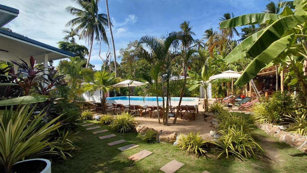 a backyard with a swimming pool and palm trees at Leelawadee Bungalow and Restaurant in Mae Nam