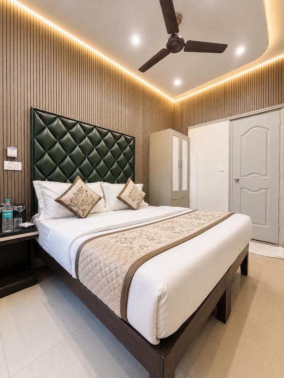 a bedroom with a large bed with a ceiling fan at Hotel Satwah Luxe Stay - 1 Minute From Nizamuddin Railway Station And India Gate in New Delhi