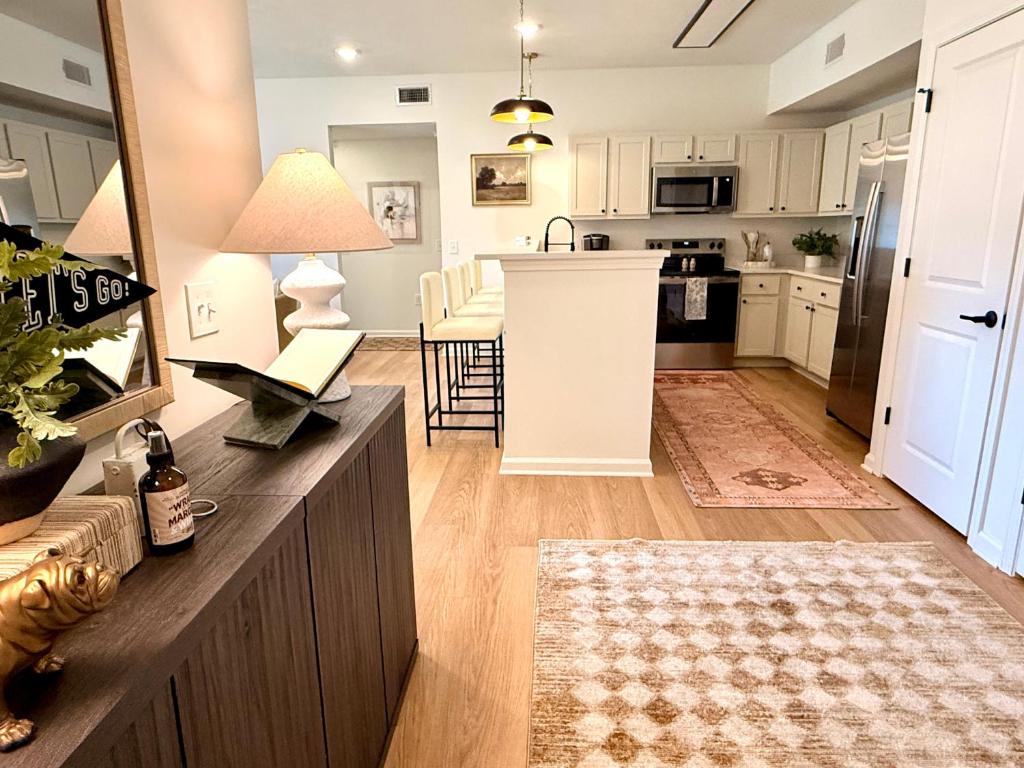 a kitchen and living room with white cabinets and a table at StarkVilla - The Perfect Location! in Starkville