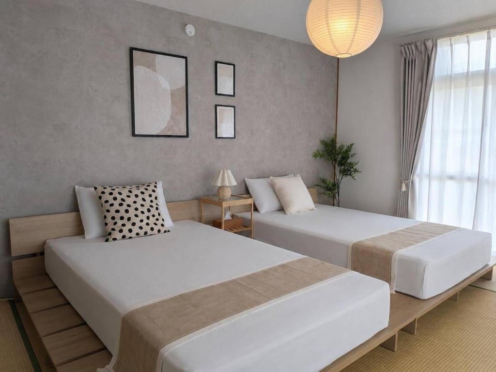 a bedroom with two beds and a lamp at Forest Agata in Matsumoto