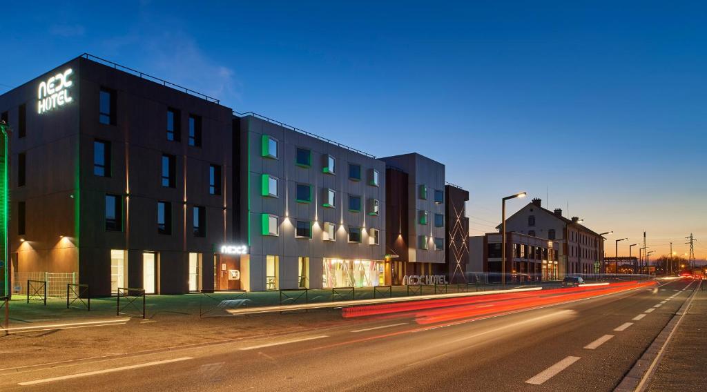 un edificio in una strada di città di notte di Nex Hôtel a Tarbes