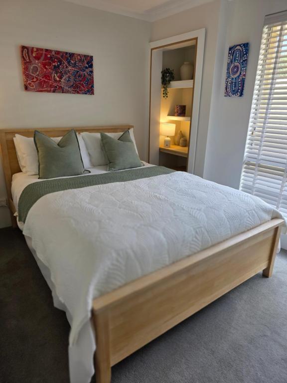 a bedroom with a large bed with white sheets at Queen bed apartment- No sharing, your very own space in Quinns Rocks