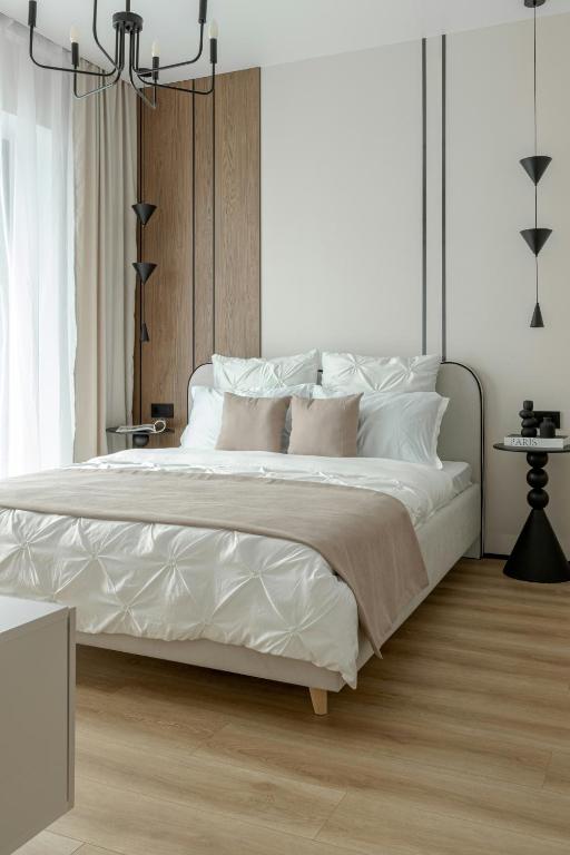a bedroom with a large bed with white sheets and pillows at Hotel Kashi Niwaas in Vrindāvan