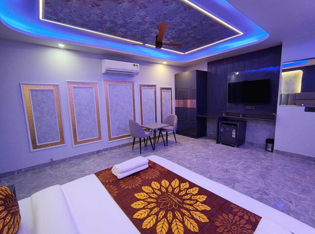 a room with a bed and a table and a tv at Hotel Smart International in New Delhi