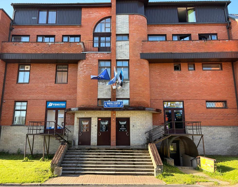 a red brick building with stairs in front of it at Narva Center Aparthotel in Narva