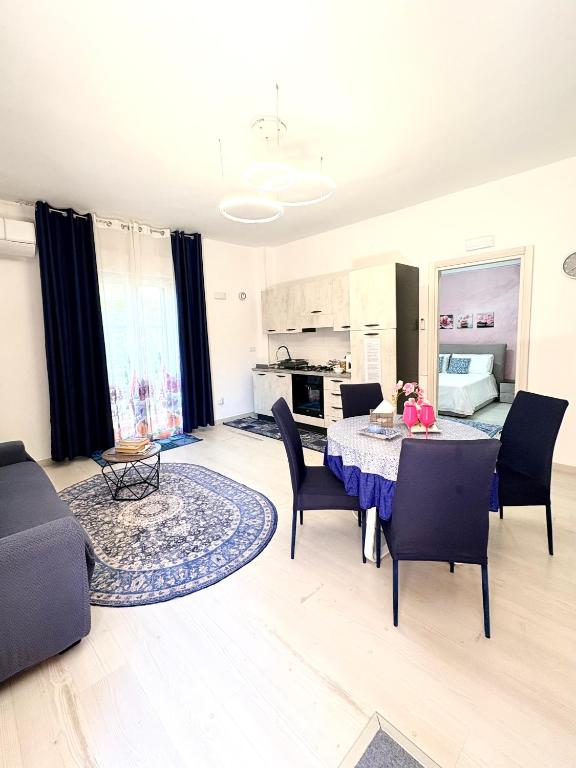 a living room with a table and chairs and a kitchen at Stefy's House in Scalea