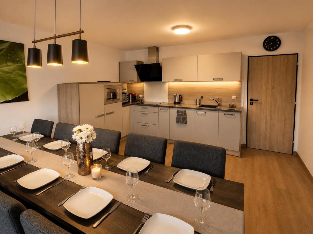 a dining room table with chairs and a kitchen at SNOW LAKE Lipno in Lipno nad Vltavou