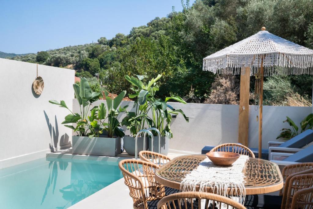 a patio with a table and chairs and an umbrella at Anamu Suites in Kondáraina