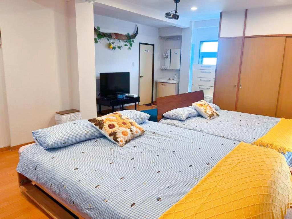 a bedroom with two beds with pillows on them at Youki Residence in Tokyo