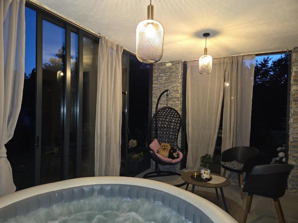 a bath tub in a room with chairs and a table at Donna in Grabovac