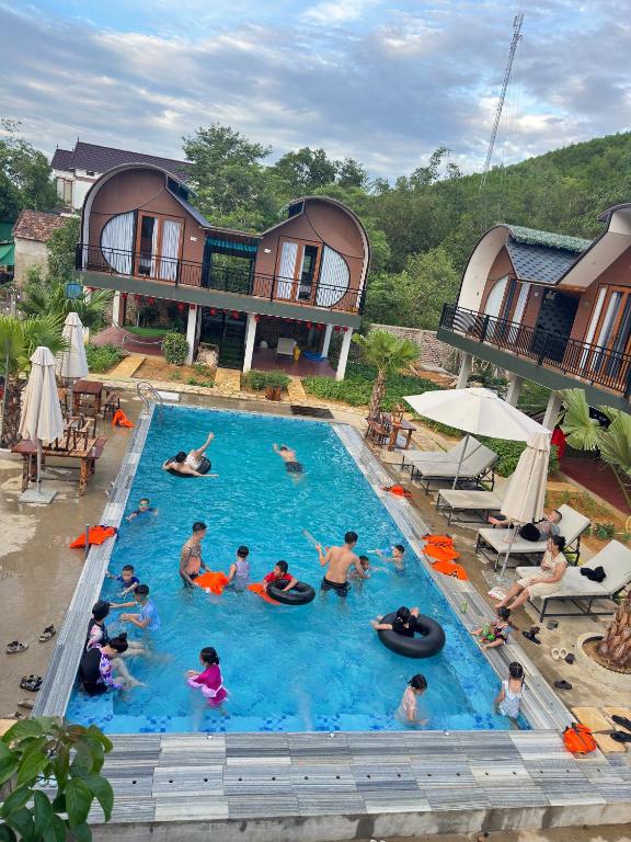 a group of people in a pool at a resort at Green Valley Retreat in Phong Nha