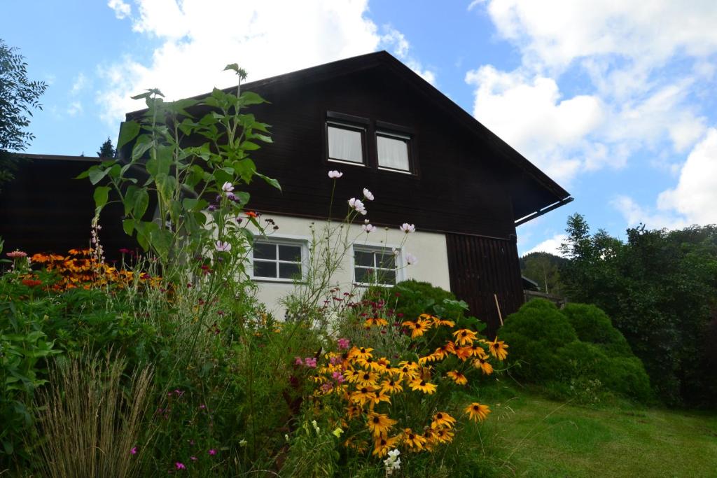 a black and white house with flowers in front of it at Eden Apartment in Glödnitz