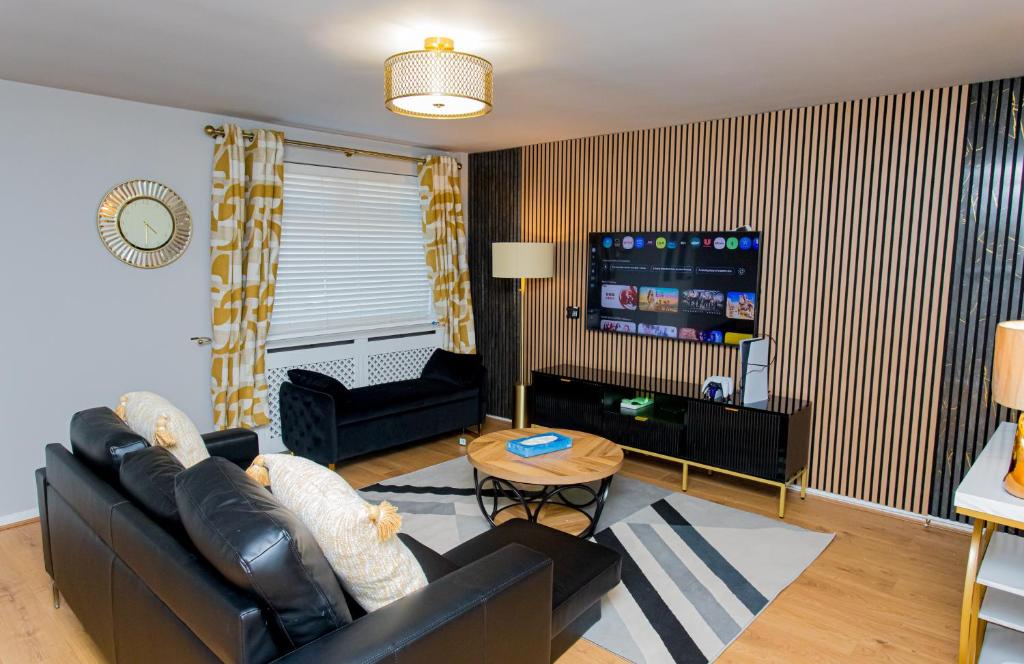a living room with a couch and a tv at The Cheshire ABode- Central Warrington- Stadium, Station Access- Sleeps 5 in Warrington