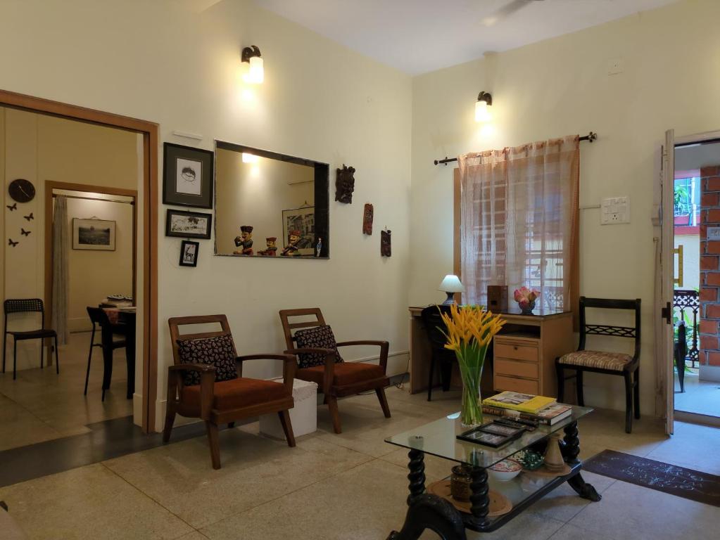 a living room with chairs and a table at Disharee 51A in Kolkata